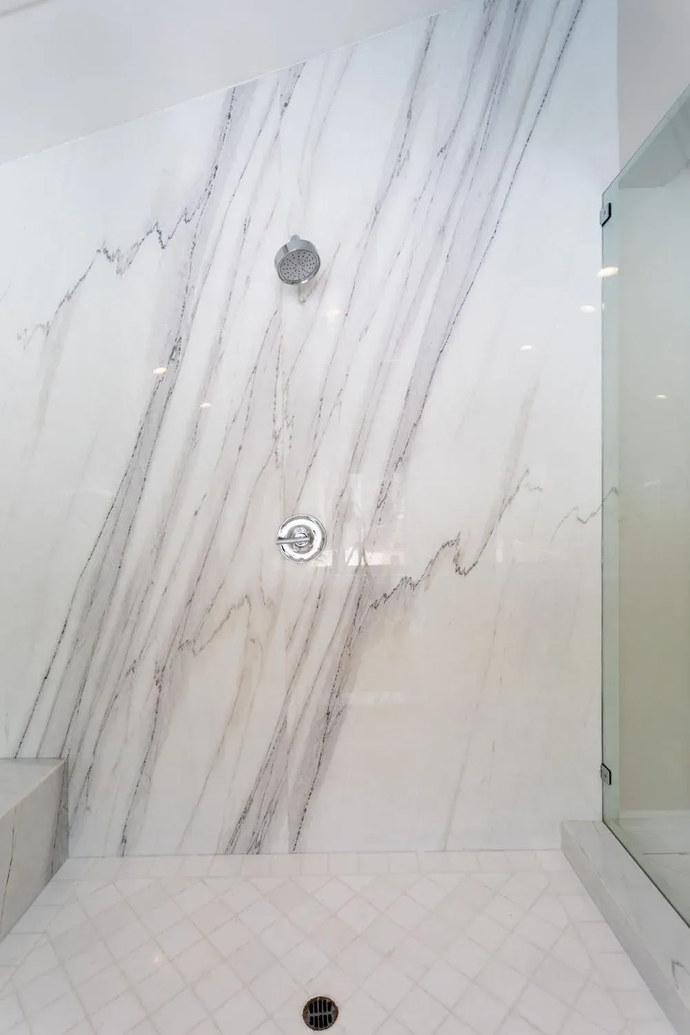 Book-matched marble shower wall with chrome fittings