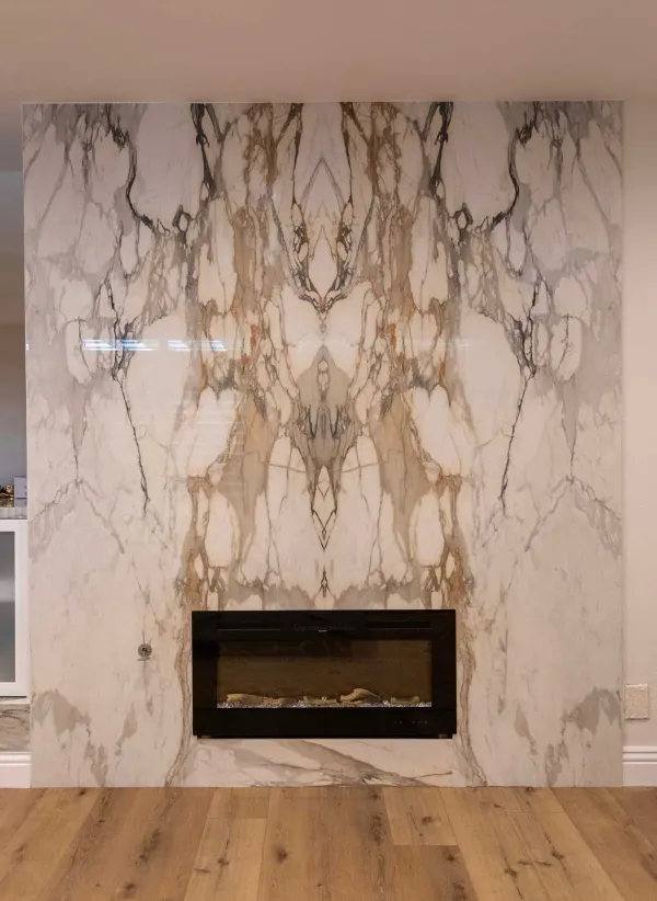 Book-matched marble slab wall rising above a fireplace