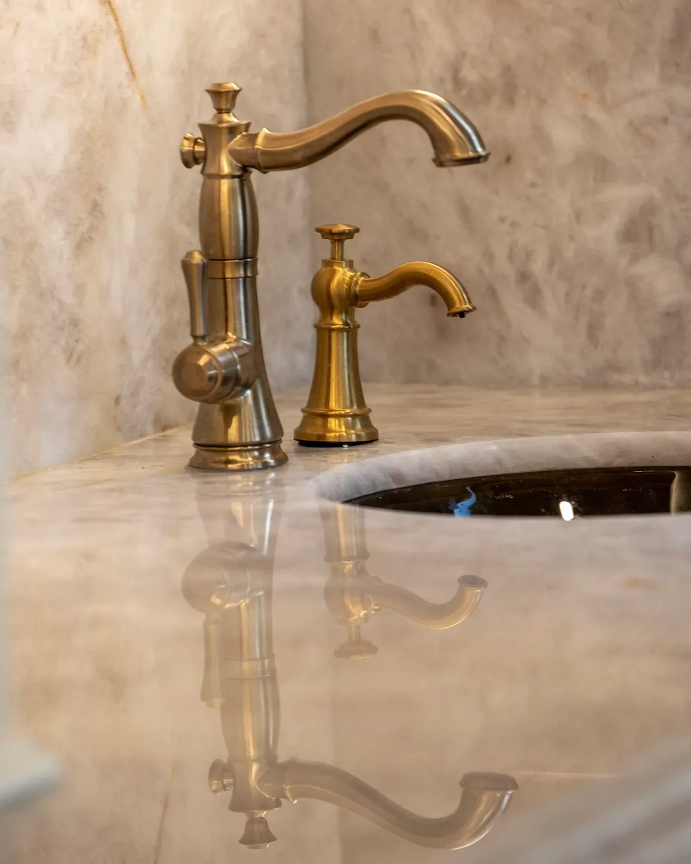 Brass tap over an undermount sink in a polished onyx worktop