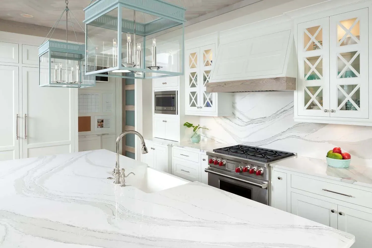 Cambria photograph of its Brittanicca quartz design on a white kitchen island and full-height backsplash, not a Kitchen Cabinets and Beyond project