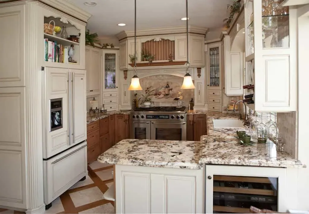 Cream kitchen with a stainless range, granite counters and glass-front cabinets