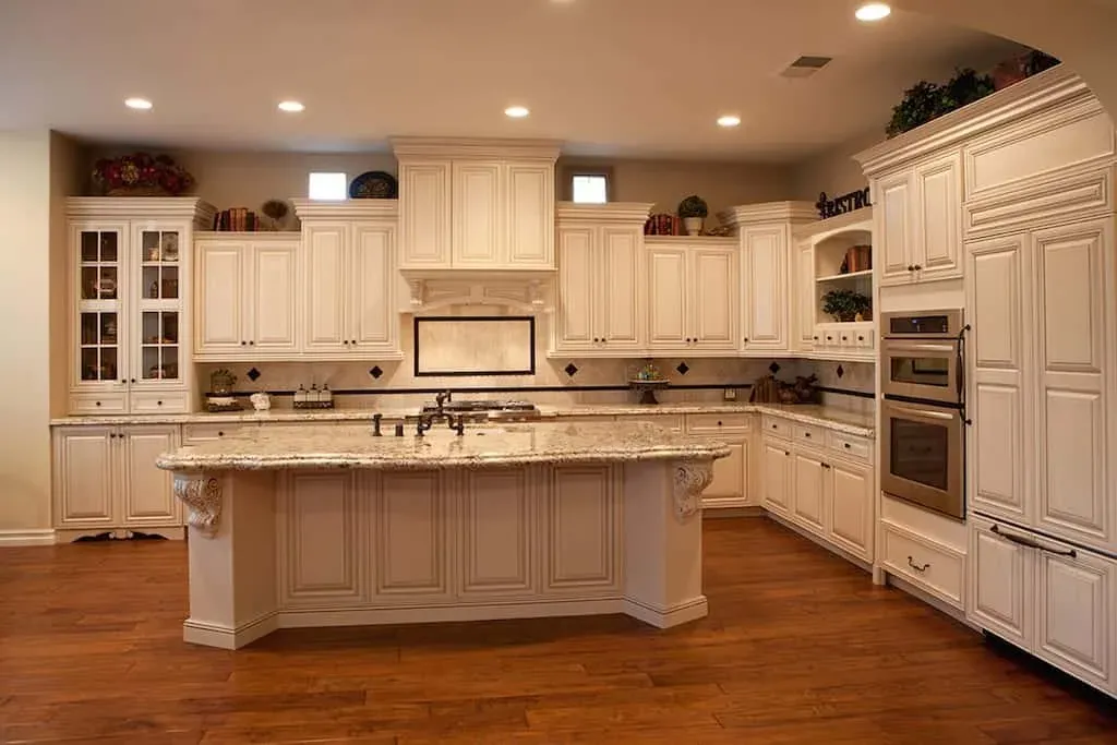 Cream traditional kitchen with a carved hood and a granite island