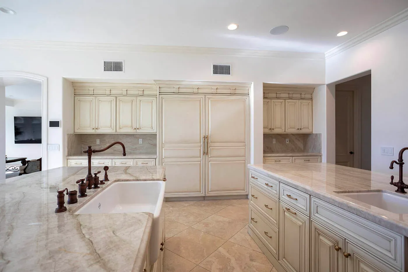 Newport Beach kitchen sink in a veined stone counter with a bronze bridge tap