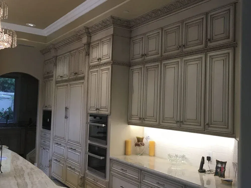 Full-height glazed cabinetry wall with double wall ovens and under-cabinet lighting