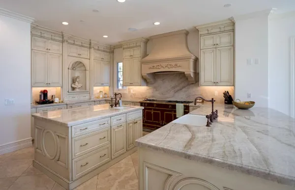 Kitchen with an arched niche, carved hood and quartzite island
