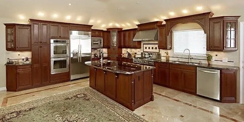 Cherry kitchen with a granite island, a travertine floor and an arched window