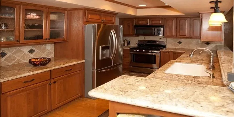 Cherry kitchen with glass-front cabinets and a granite peninsula with a sink