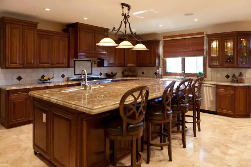 Cherry kitchen with a granite island, carved chairs and a wrought-iron chandelier