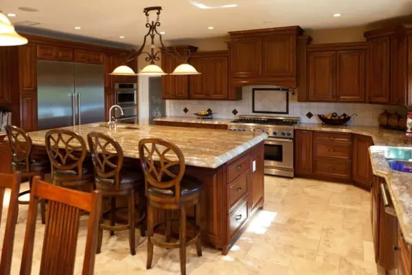 Cherry wood kitchen with a granite island, carved bar stools and a stainless range