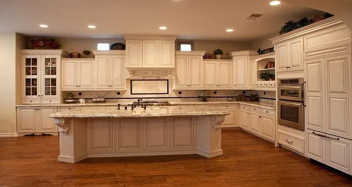cream ornate kitchen with large island, carved corbels and dark hardwood flooring