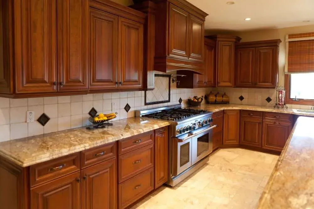 Cherry kitchen with granite counters, a diamond-set tile backsplash and a stainless range