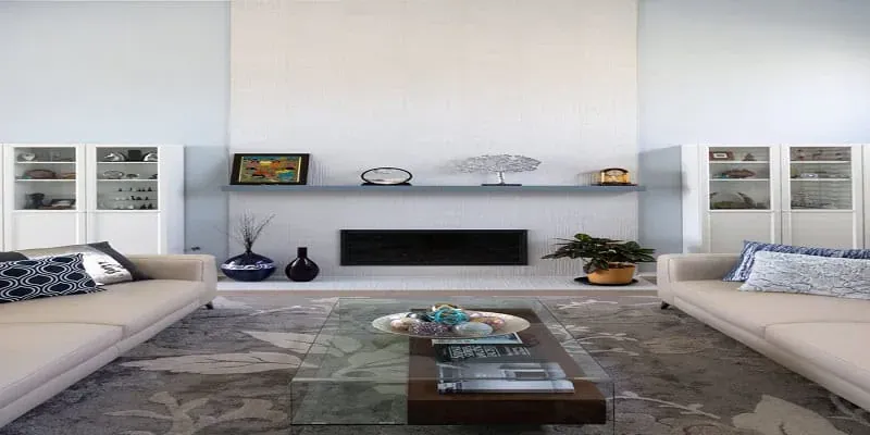 Living room with a linear fireplace flanked by built-in glass cabinets, two cream sofas and a glass coffee table