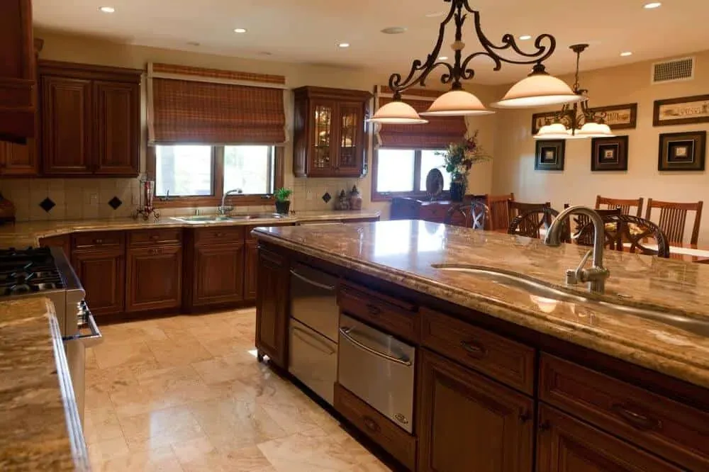 Cherry kitchen with a long granite island and pendant lamps, open to the dining room