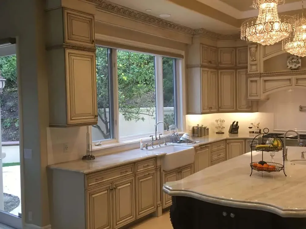 Lake Forest kitchen with a window over the sink, a crystal chandelier and a large glazed island