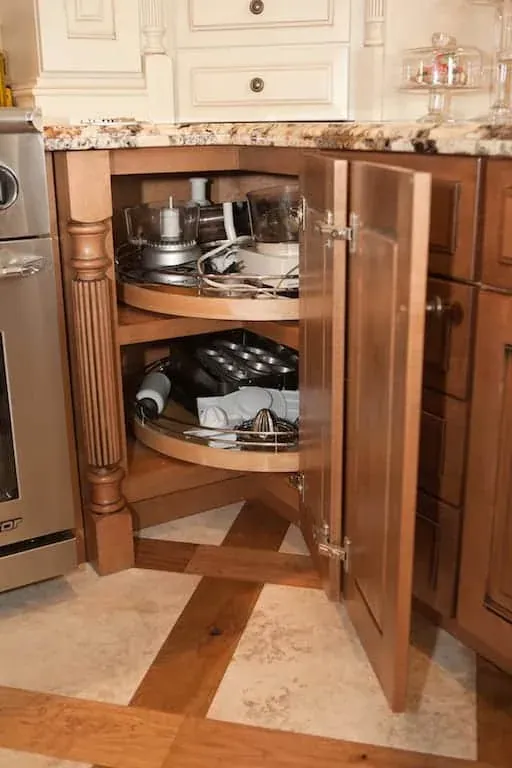 Open corner cabinet with a rotating carousel holding cookware