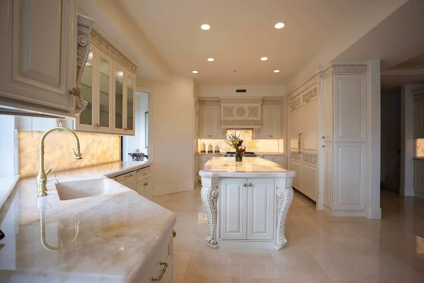 Laguna Hills kitchen with a backlit onyx counter beside a carved cream island
