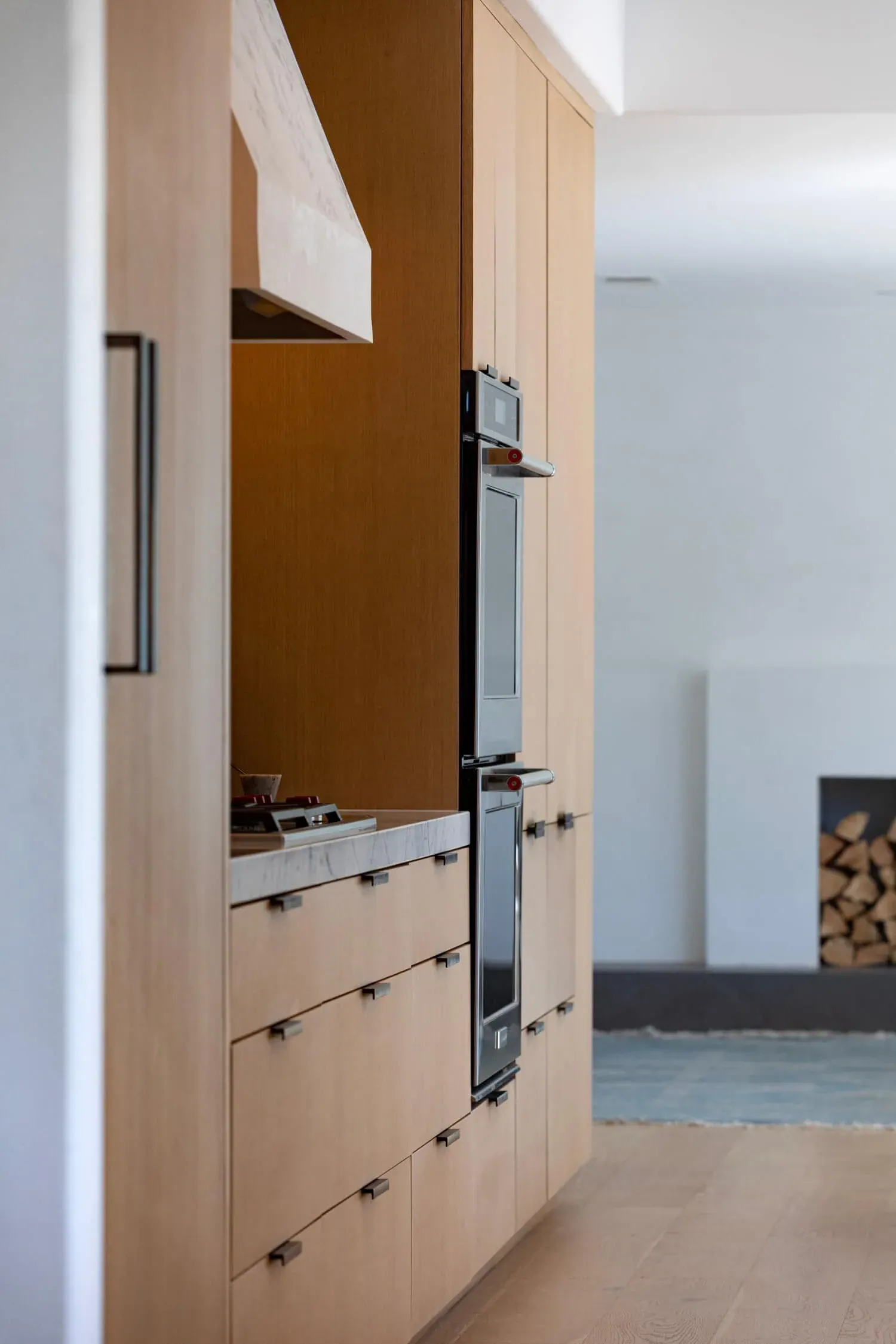 Tall panelled oak cabinetry standing beside a stainless wall oven