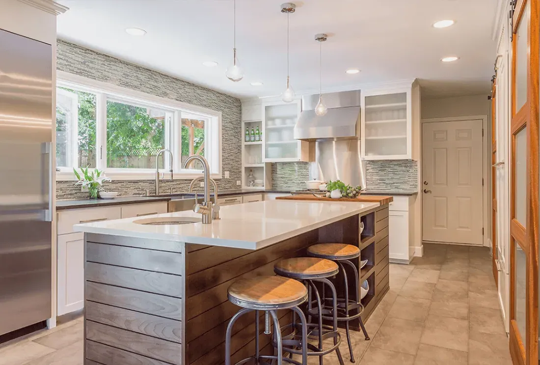 White island with a slatted end panel and bar stools in front of a window wall