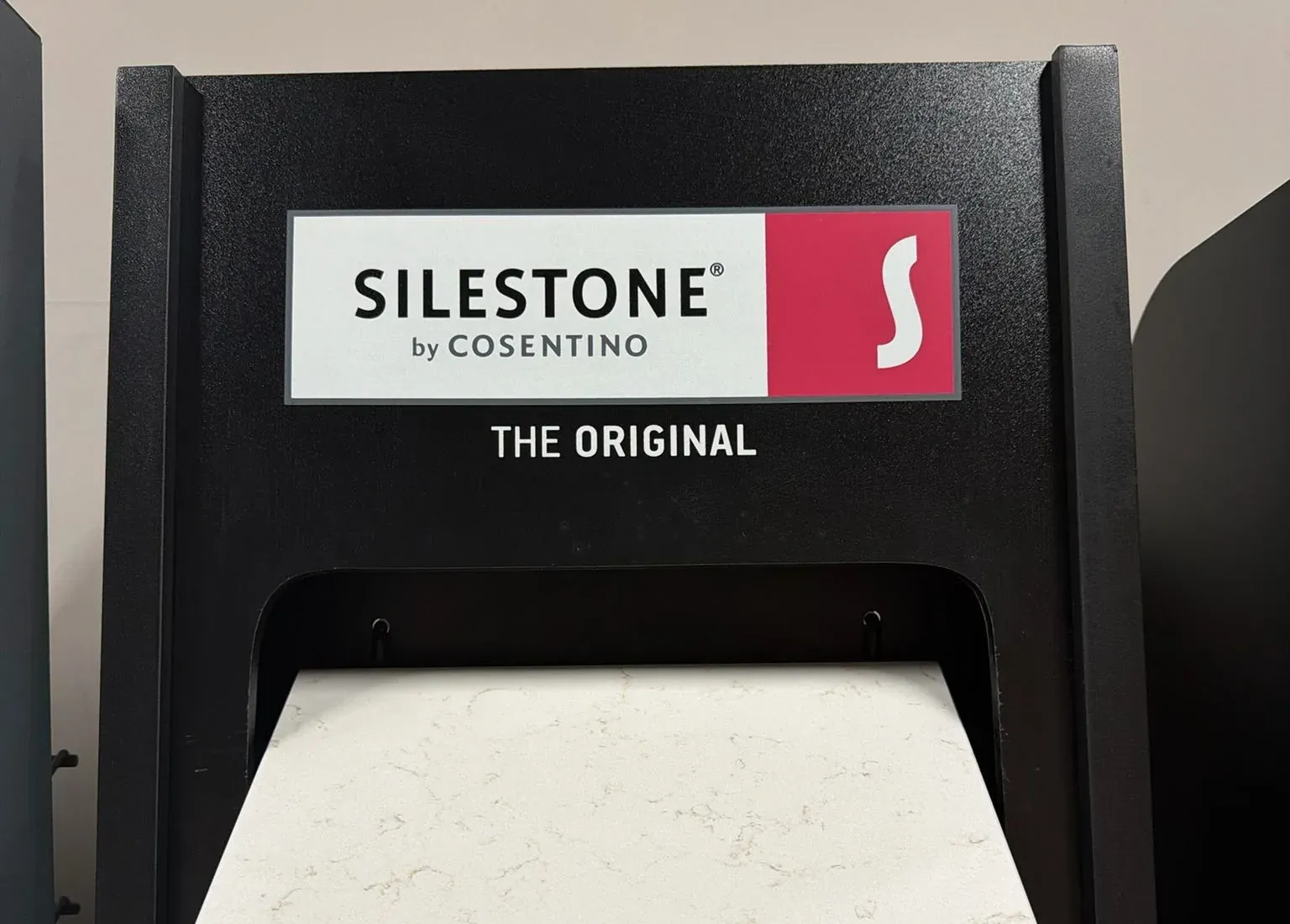 Silestone by Cosentino sample stand in the Kitchen Cabinets and Beyond showroom with a white veined quartz sample pulled out
