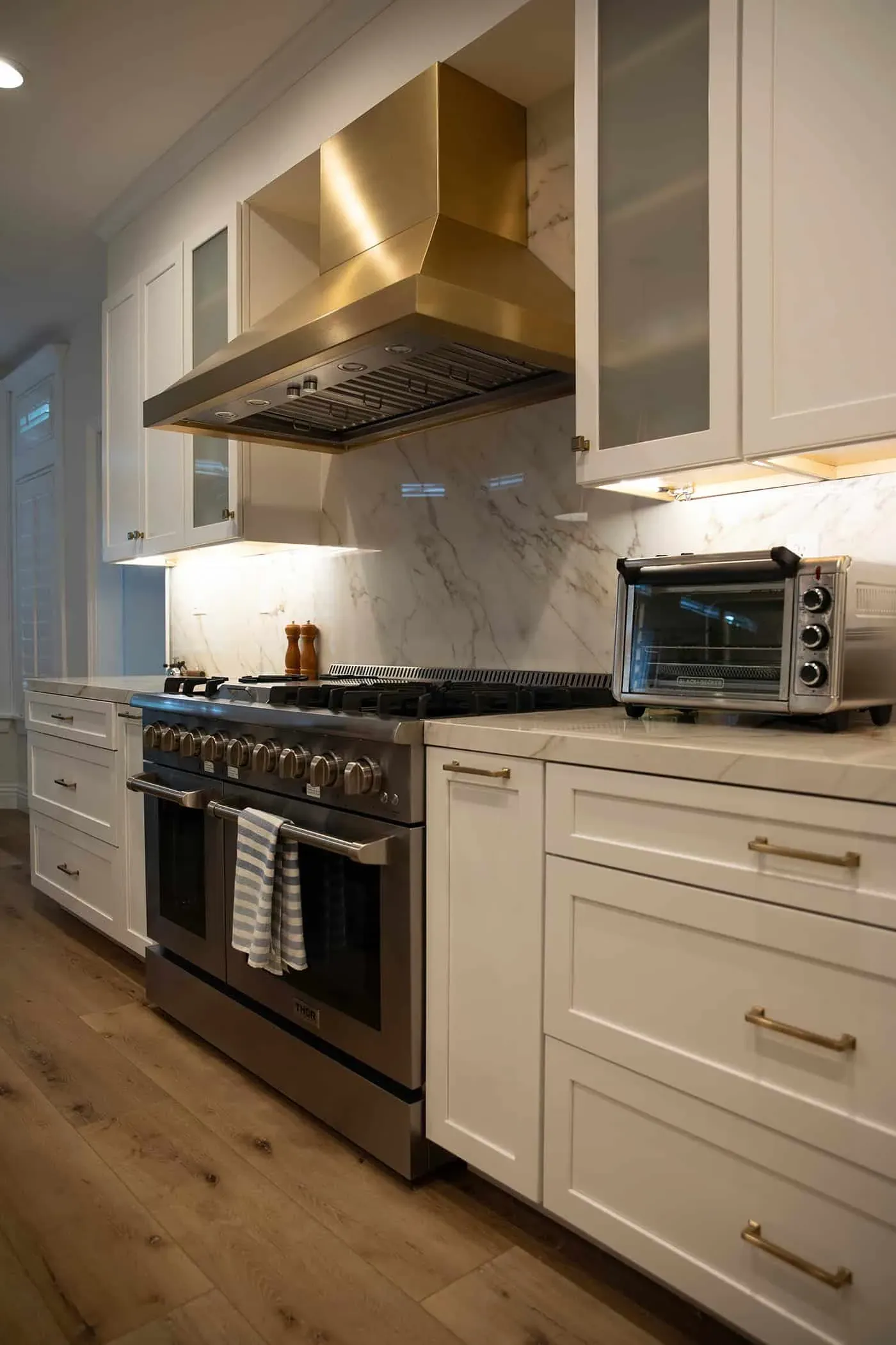 Stainless range with a wall-mounted extractor between marble counters