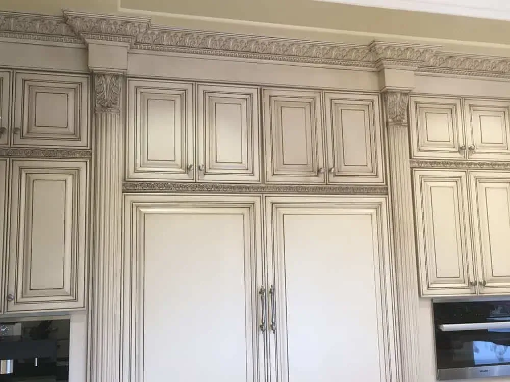 Lake Forest kitchen wall of tall glazed cream cabinetry with panelled appliance fronts