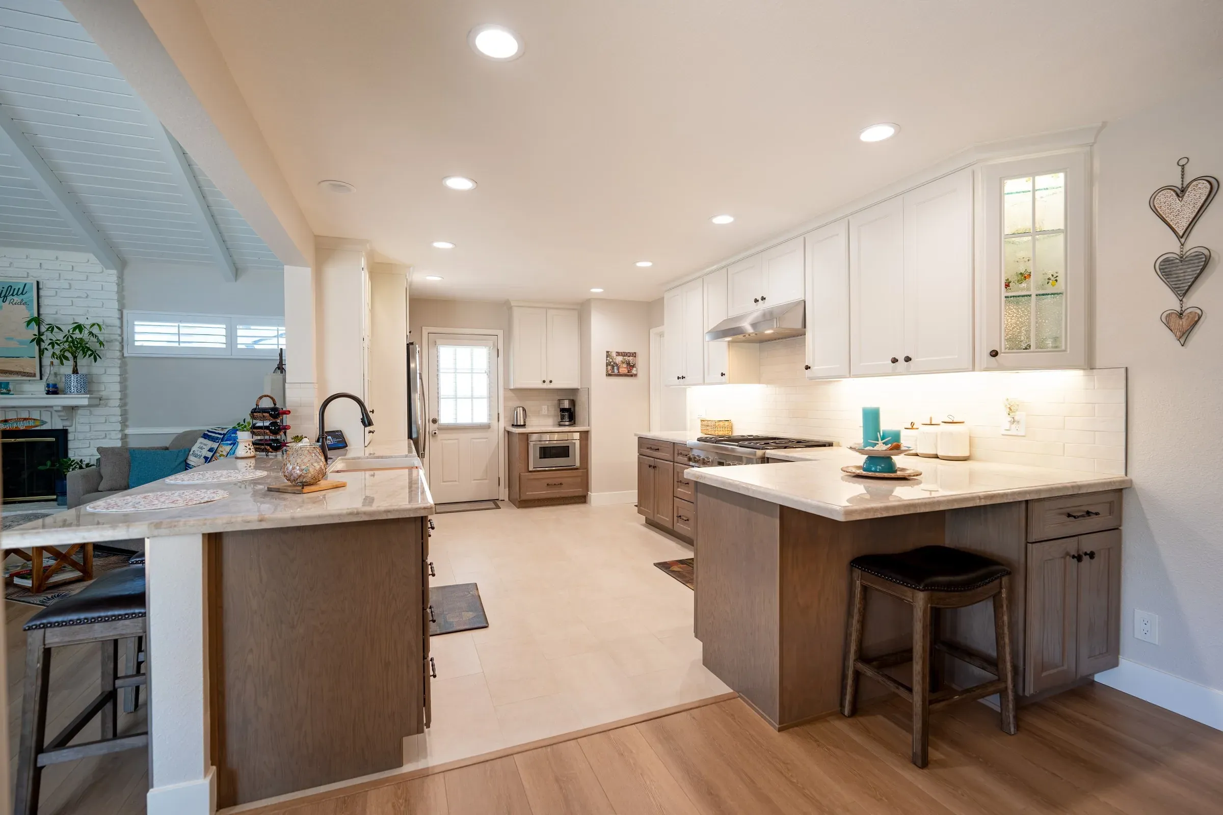 Westminster kitchen after the remodel, with a stone-topped wood island, white upper cabinets and a new floor