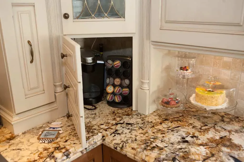 Cream cabinetry with a built-in coffee machine above a granite counter
