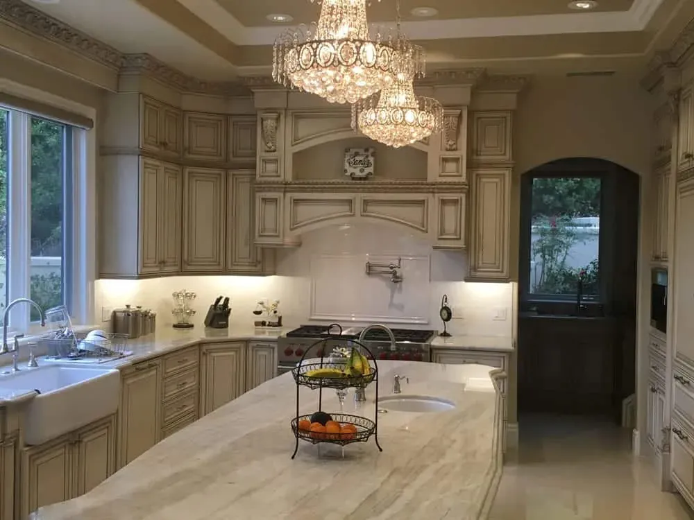 Lake Forest kitchen seen wide, with a chandelier, the island, the range hood and an arched door